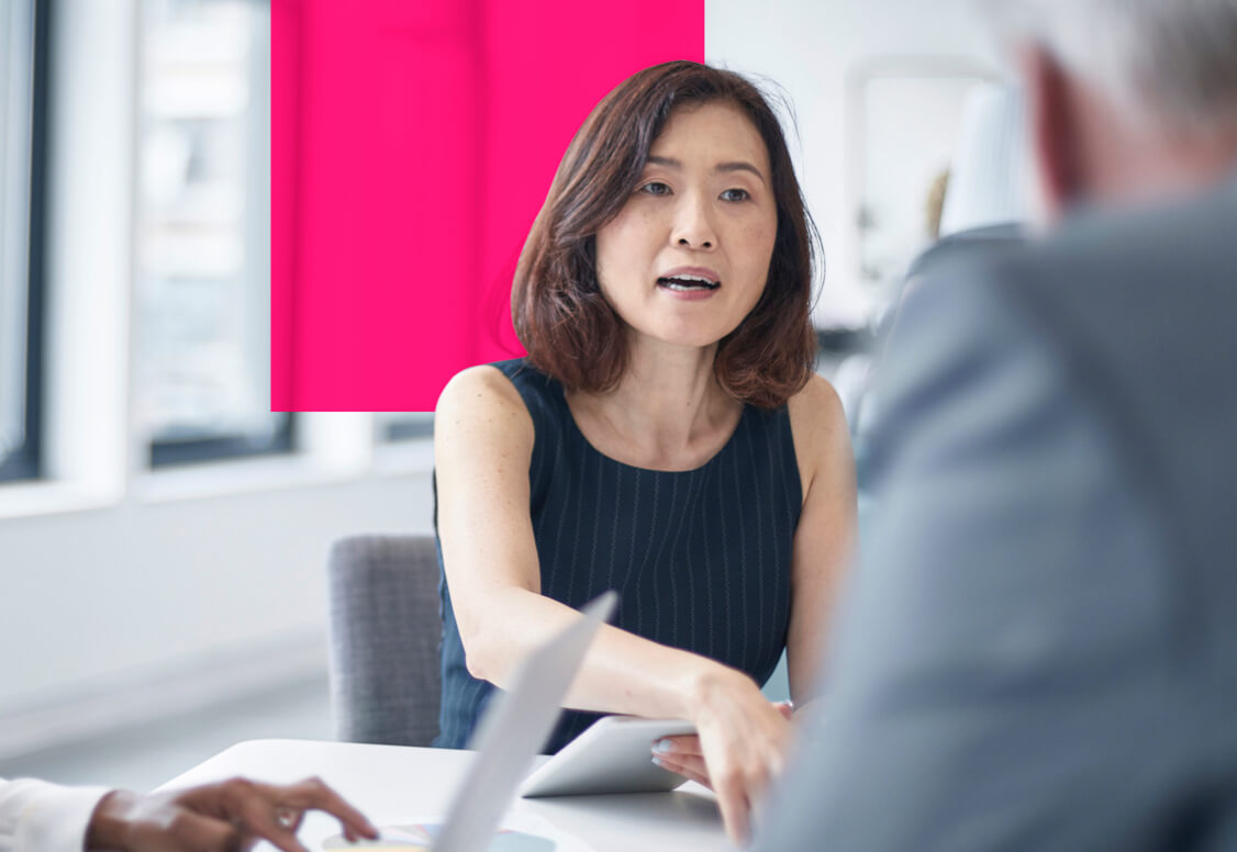 Three people having a discussion around a table