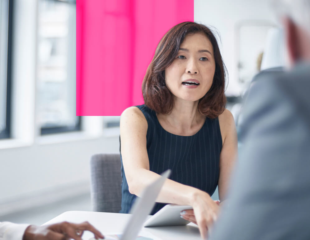 Three people having a discussion around a table